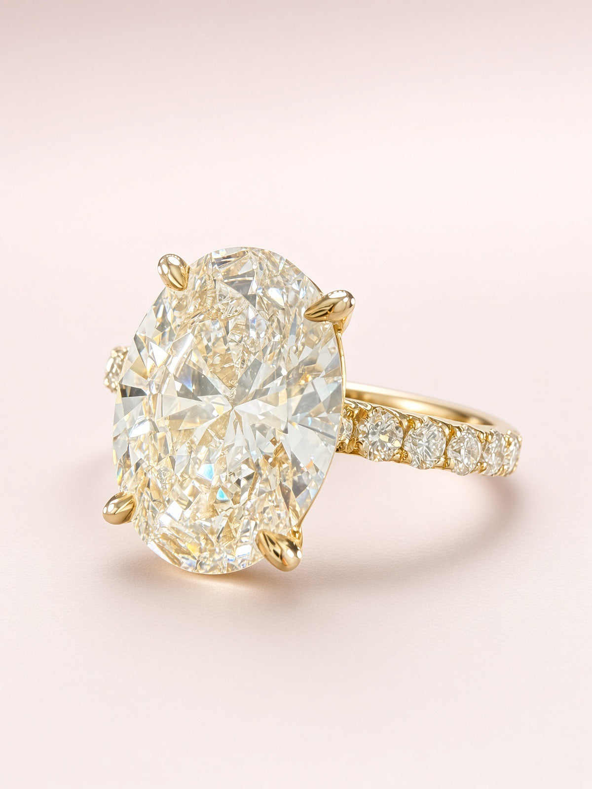 Side profile of an oval diamond pavé ring showing the raised yellow-gold setting.