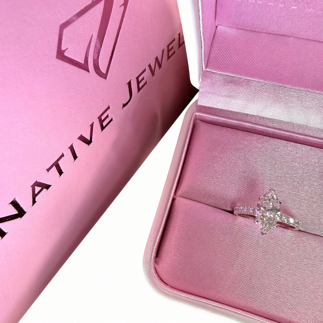 Marquise diamond pavé ring in a pink ring box beside Native Jewel packaging.