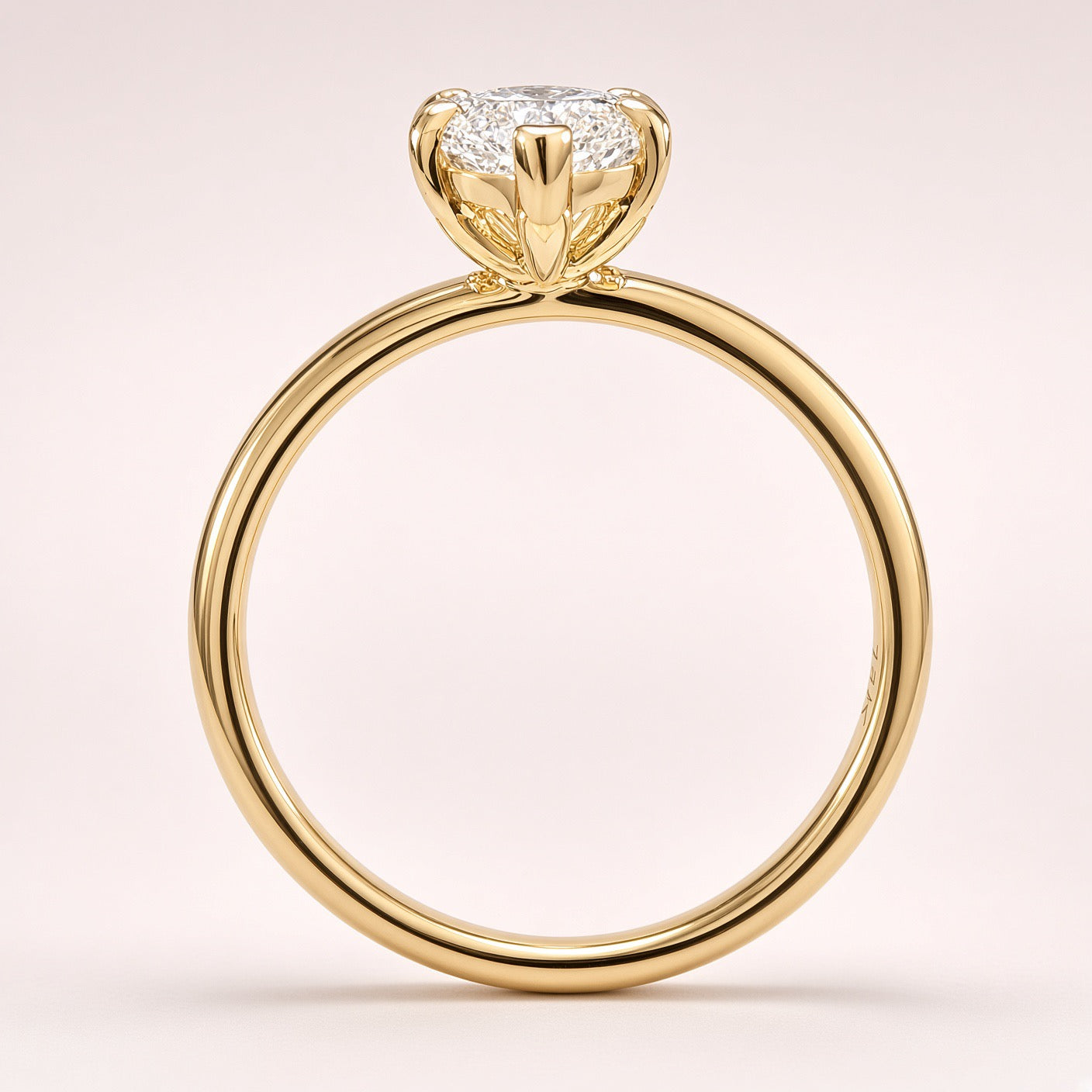 Side profile of a diamond solitaire showing an open yellow-gold basket and a plain polished band on pale pink.