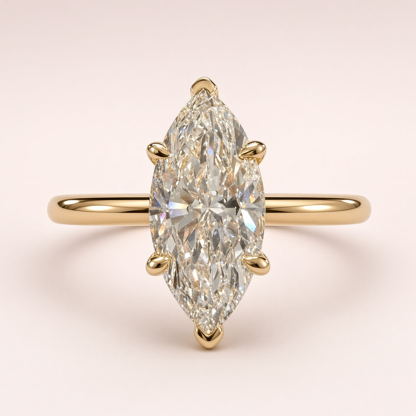 Front close-up of a marquise diamond solitaire with yellow-gold prongs protecting both tips and a plain band.