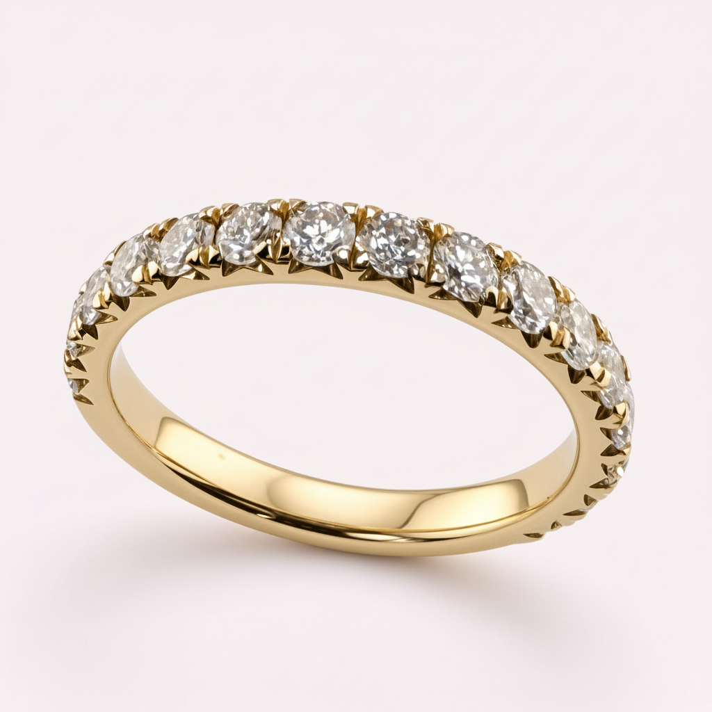 14K yellow gold 2.5mm French pavé round diamond wedding band on pale pink background