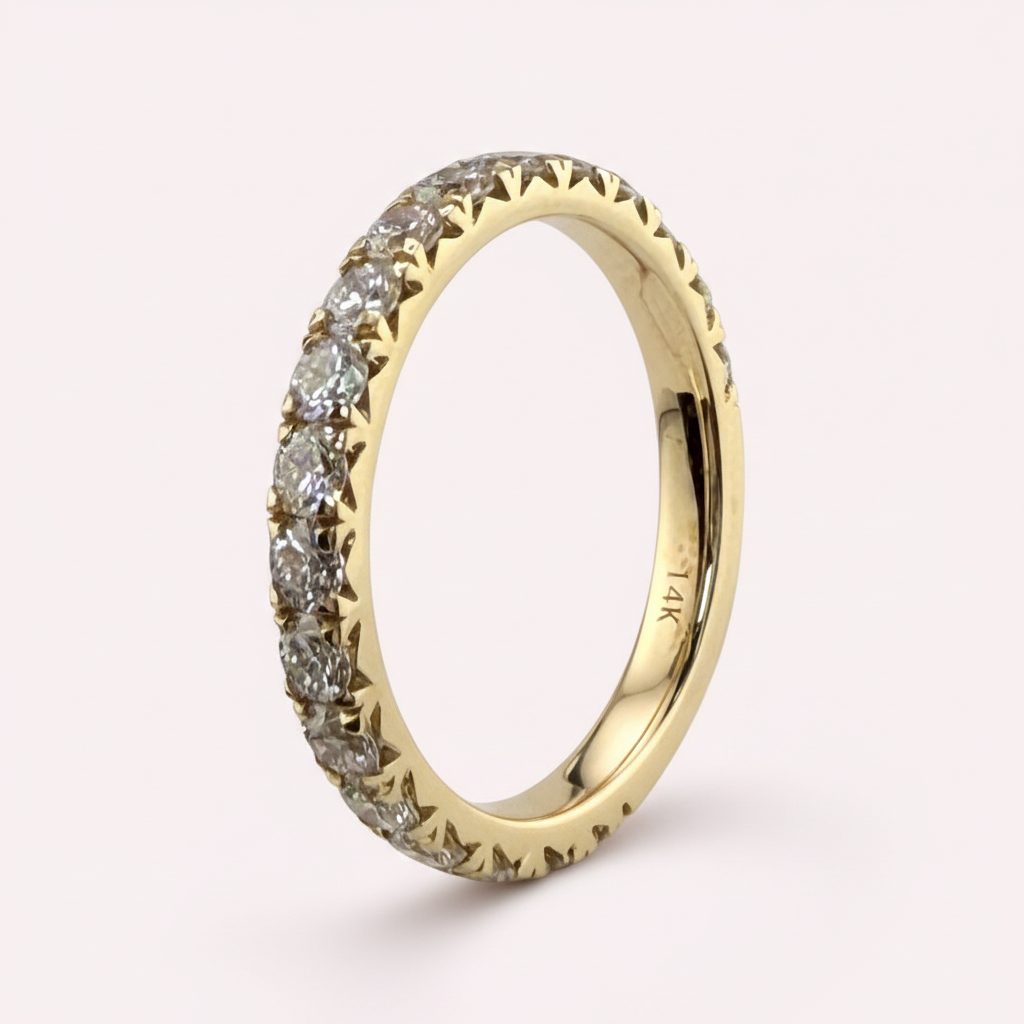 14K yellow gold 2.5mm French pavé round diamond wedding band on pale pink background
