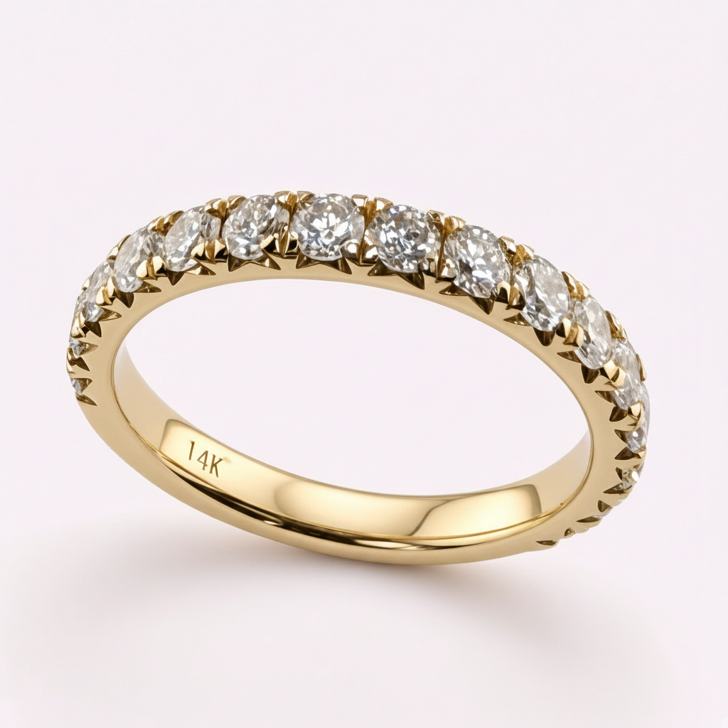 14K yellow gold 2.5mm French pavé round diamond wedding band on pale pink background