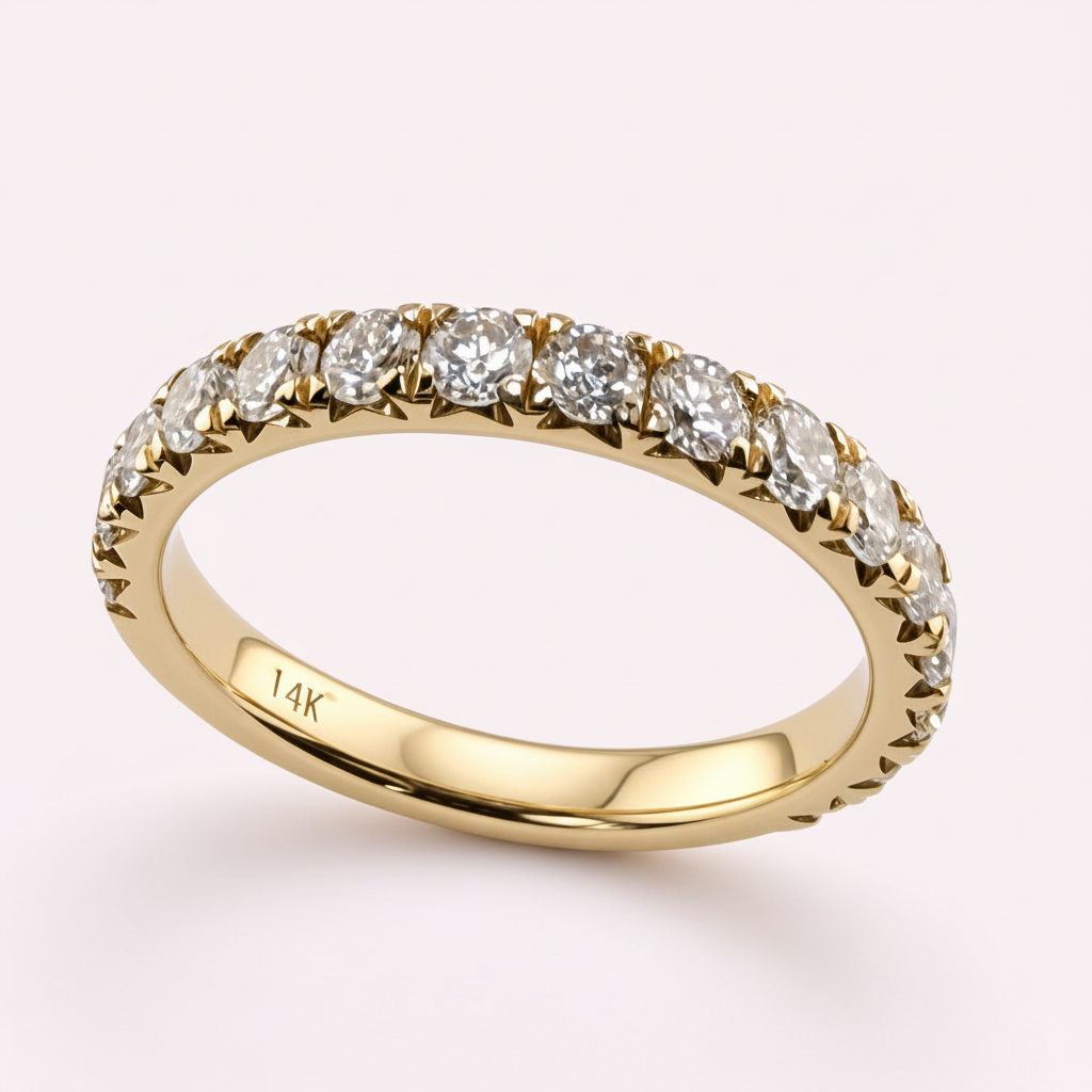 14K yellow gold 2.5mm French pavé round diamond wedding band on pale pink background